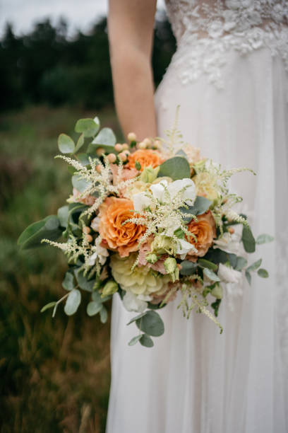 istock bride holding her wedding flowers with rose colored roses 1746351809