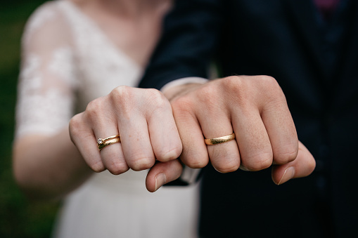 bridal couple showing rings by making a fist