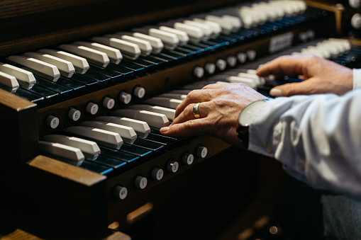 Close up of an organist plays on an organ