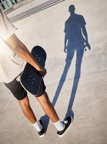 Skateboard, city and man skate in park athlete ready for training, fitness and skate park exercise. Sports, workout and person from Los Angeles holding a board in the sun on concrete for sport