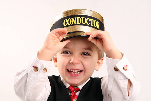 Young Boy Role Playing as a Train Conductor Young Boy Role Playing as a Train Conductor as he holds his Conductor Hat. transport conductor stock pictures, royalty-free photos & images