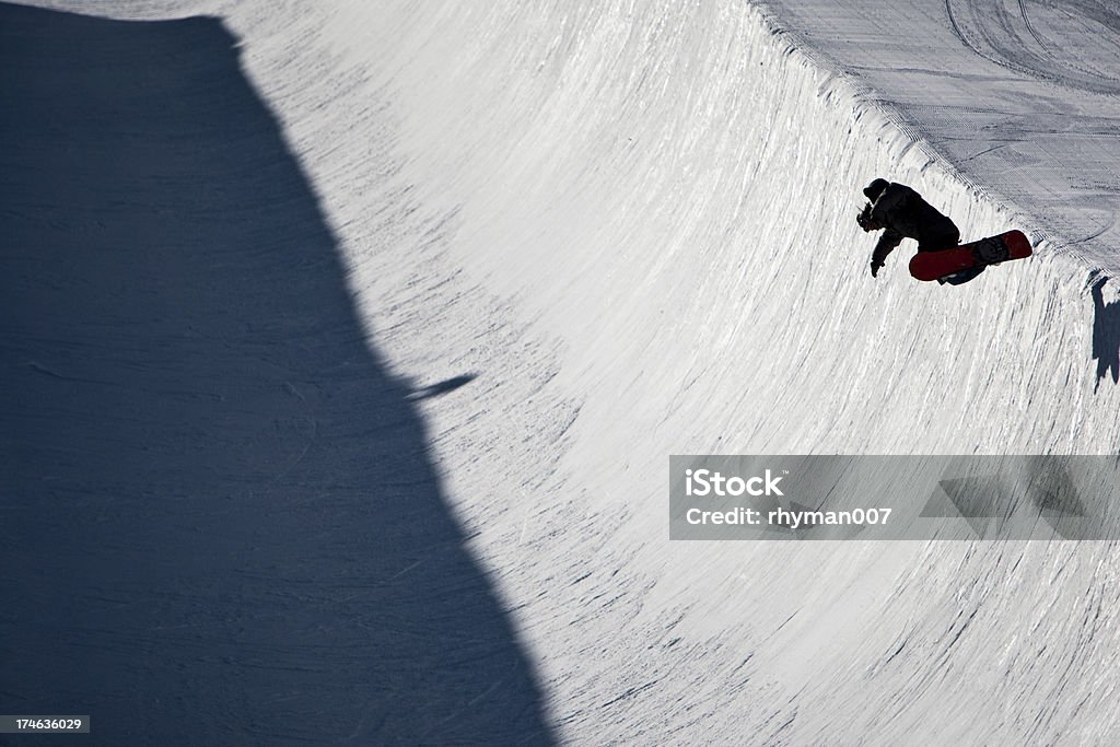 Boarder on a half pipe A snowboarder is in the air on a half pipe in prk city utah. Half Pipe Stock Photo