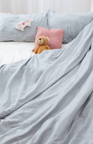 istock bed with teddy bear on gray linens 1746361617