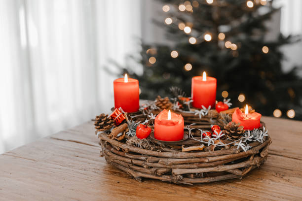 Advent wreath made of branches with four candles burning on Christmas Eve. Advent wreath made of branches with four candles burning on Christmas Eve. Hygge time at home with family and friends. advent candle wreath adventskranz stock pictures, royalty-free photos & images