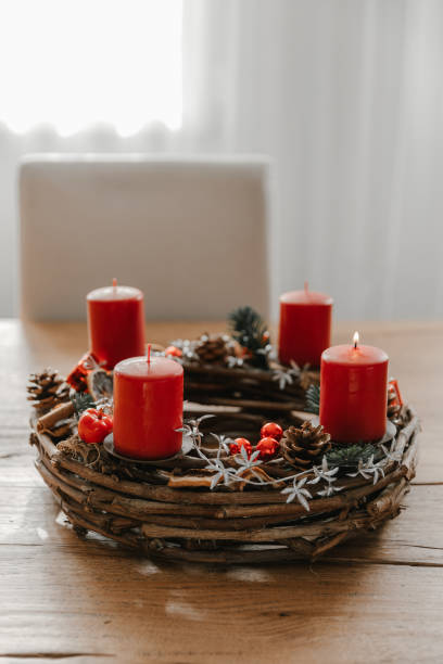 First candle lit on advent wreath made with branches. First candle lit on advent wreath made with branches. Cozy home in winter time. advent candle wreath adventskranz stock pictures, royalty-free photos & images