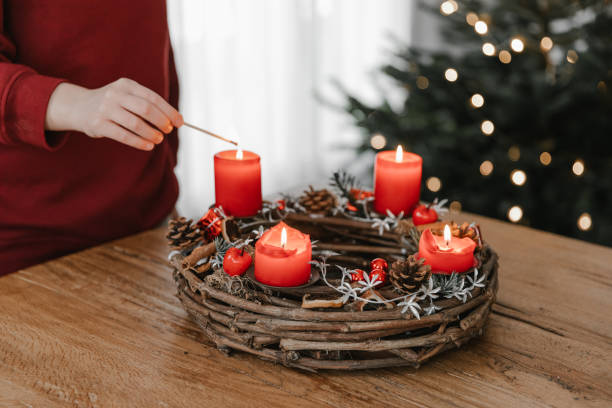 istock Human hand lighting all four candles on rustic advent wreath on Christmas Eve. 1746378549
