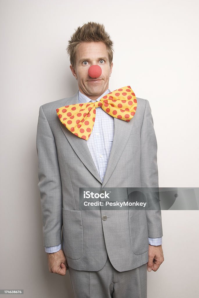 Professional Clown at Your Service Businessman with big floppy clown tie and red nose stands by looking rather silly Men Stock Photo
