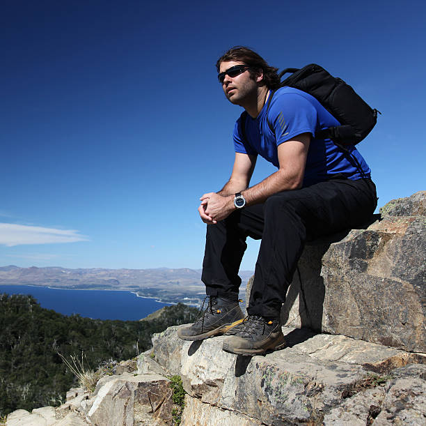 hombre sentado y pensar en la cumbre de la montaña - argentina bariloche people hiking fotografías e imágenes de stock