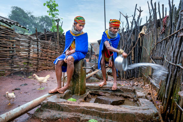 deux femmes vêtues de leurs costumes traditionnels de la tribu bonda de la région d’odisha en inde vont chercher de l’eau à l’un des robinets du village - asian tribal culture photos photos et images de collection