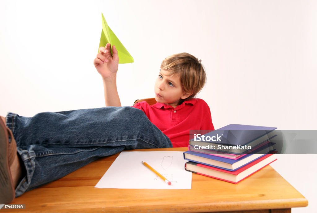 Estudiante aburrido jugando con avión de papel soñar despierto - Foto de stock de Aburrimiento libre de derechos