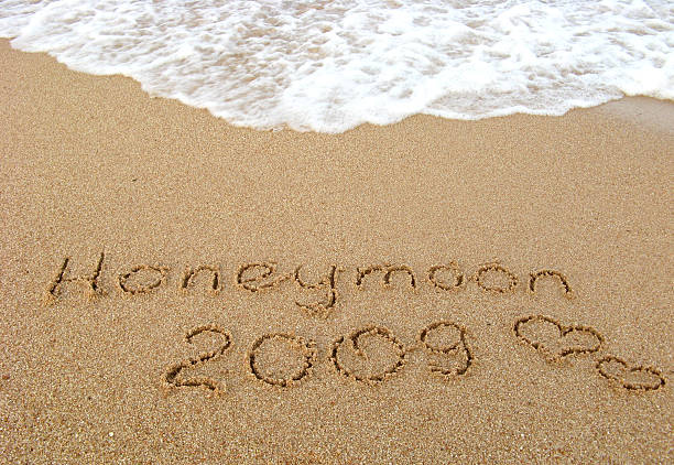 istock Honeymoon 2009 written on sand 174640289
