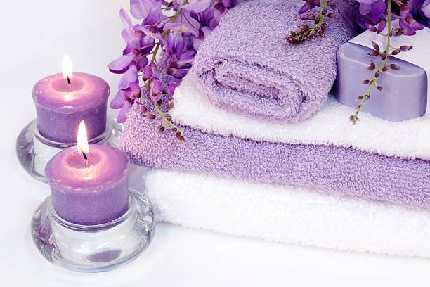 Spa Tranquility with purple candles, towels, wisteria and soap stock photo