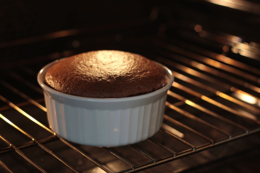 A chocolate soufle baking in a white ramekin.All images in this series...