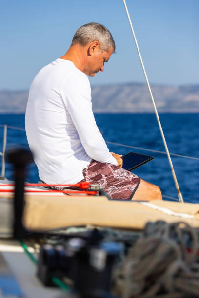 istock Businessman with laptop on sailboat 1746414562