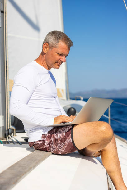 istock Businessman with laptop on sailboat 1746415683