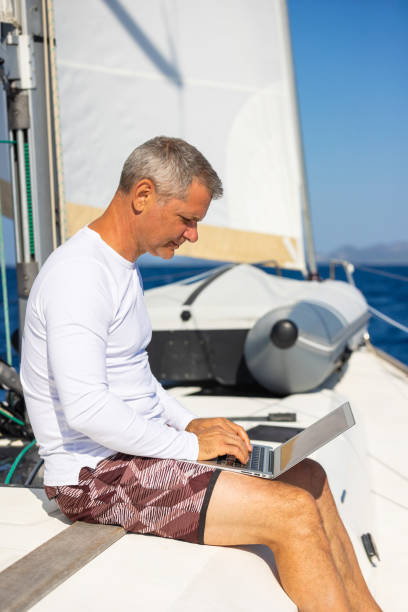 istock Businessman with laptop on sailboat 1746416821