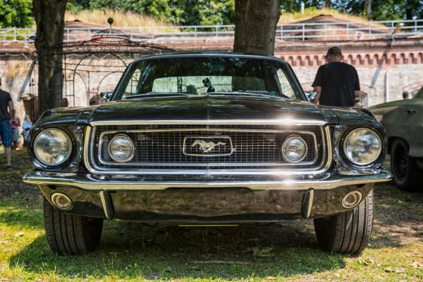 Stade, Germany – July 9, 2023: A Vintage Ford Mustang Coupé from 1968 exhibited at Summertime Drive US Car meeting. Low angle front view.