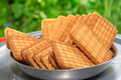 Brown Wheat biscuits in the steel plate with blury background. Tea Biscuit morning breakfast