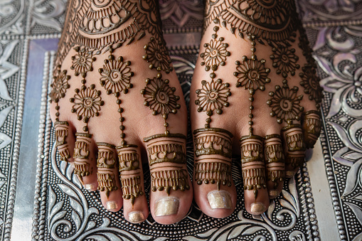 Henna decoration on the feet of the bride during a religious ceremony at a Hindu wedding in Canada.
