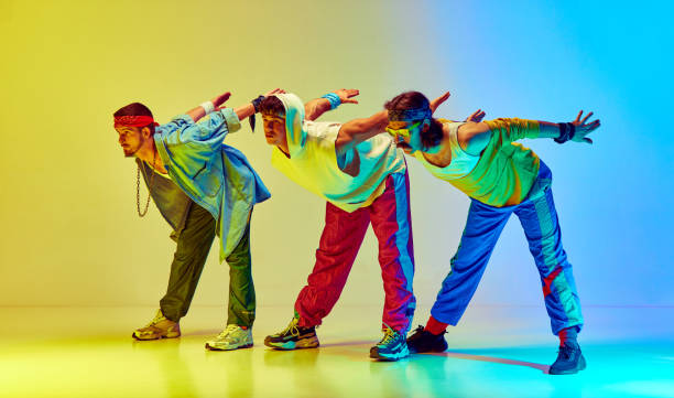 istock Stretching and warming up exercises. Stylish an in retro sportswear training against gradient yellow blue background in neon light 1746441650