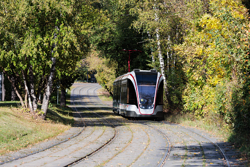 Tram on the road in the autumn forest. Moscow, Russia