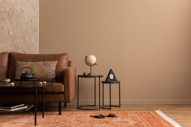 istock Minimalist composition of living room interior with copy space, brown sofa, patterned rug, slippers, black coffee table and personal accessories. Home decor. Template. 1746452384