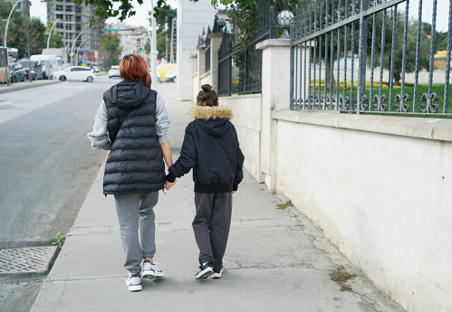Grandmother and granddaughter walking on the street