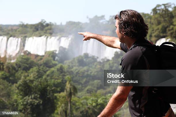 Photo libre de droit de Homme Pointant Les Chutes Diguazu Argentine banque d'images et plus d'images libres de droit de Tomber - Tomber, parc national d'iguazu, 25-29 ans