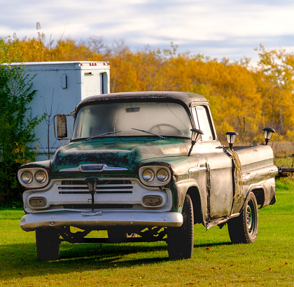 Old farm pickup truck covered in dew in an early autumn morning