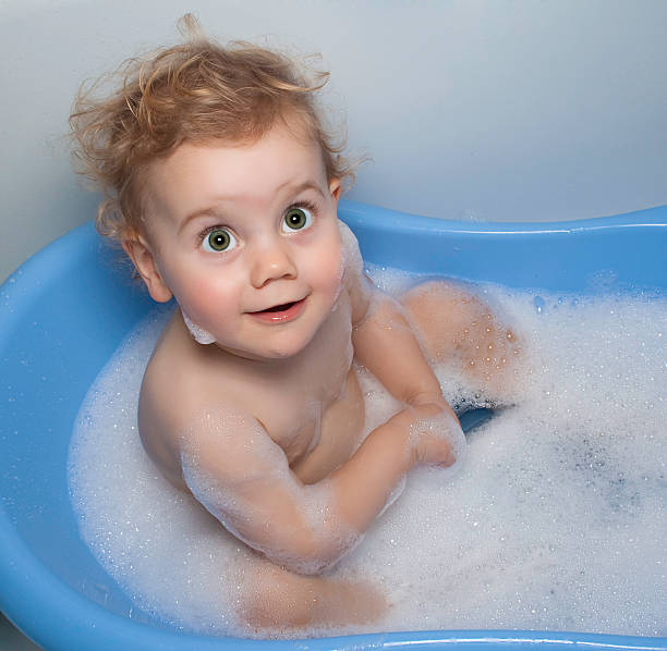 Baby girl in a bath stock photo