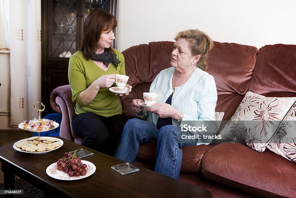 2 重篤な女性、ピンクのソファに座るティーます。 - 噂のロイヤリティフリーストックフォト