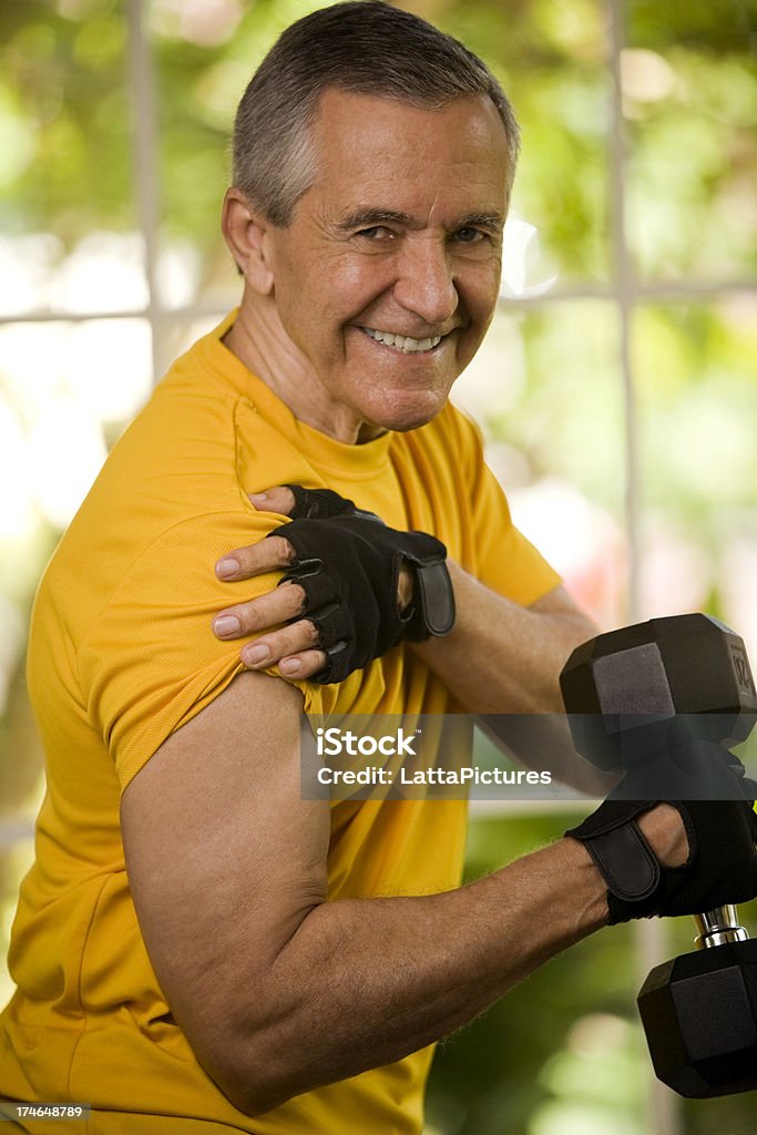 Senior homme tenant haltère et contracter montre biceps musculaire - Photo de Activité libre de droits