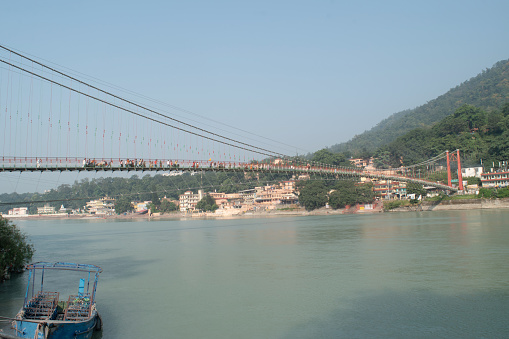Ram jhula bridge view with holy ganga and mountain at rishikesh