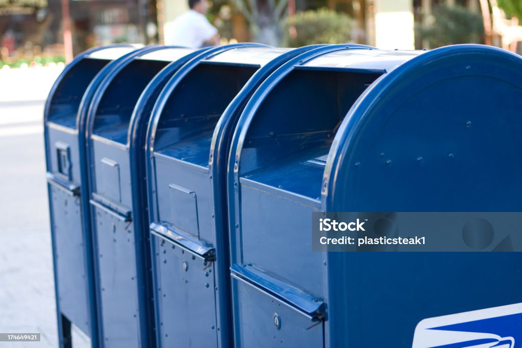 Four bright blue USPS mailboxes in a row A row of blue mailboxes. United States Postal Service Stock Photo