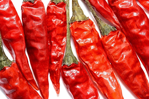 Frame of Flying green and red chili pepper, leaves on white background. Seasoning for dish, fresh hot pepper, spicy spices for cooking, cayenne pepper, food. Creative concept of food, vegetables.