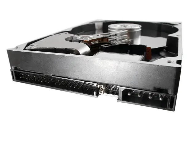 The inside of a hard drive isolated one white. Focus on the power and IDE connectors.