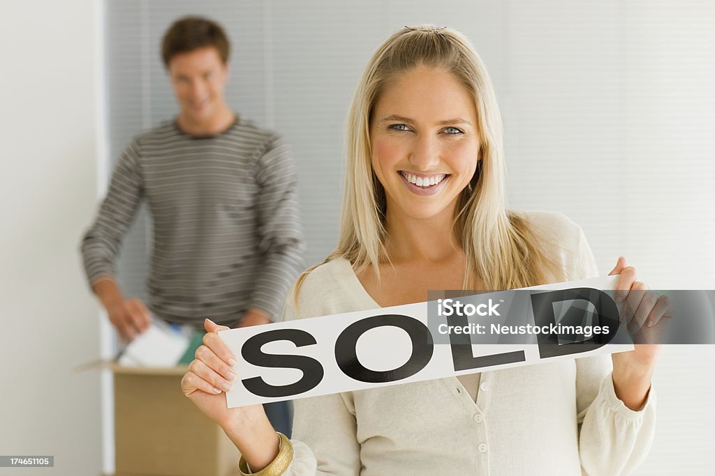 Jovem Menina segurando vendidos placa com Homem no fundo - Royalty-free Sold - Palavra inglesa Foto de stock