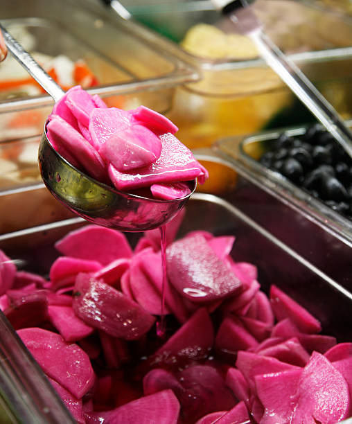 Ladling red turnip Being served red turnip at the take out store. pickled turnip stock pictures, royalty-free photos & images