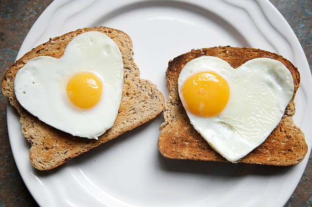 romántico desayuno saludable dos corazones en tostadas - eggs breakfast heart shape fried egg fotografías e imágenes de stock