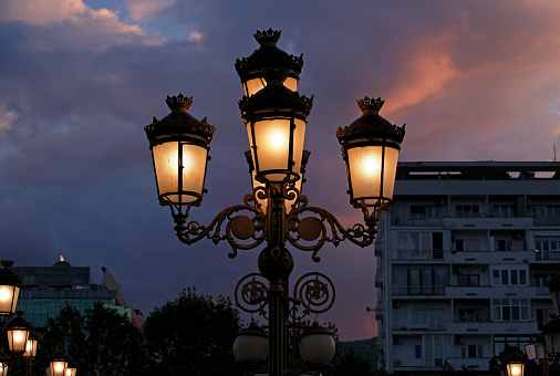 Streetlights in Skopje, North Macedonia, against a dramatic evening sky