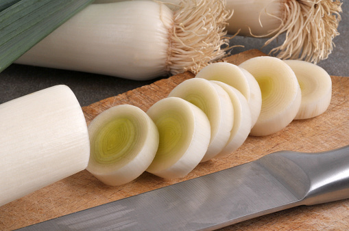 Raw leeks cut into slices with a knife close-up