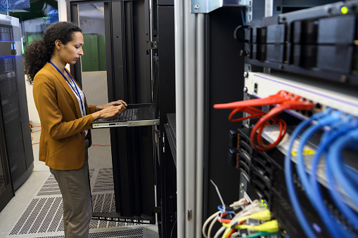 Woman in data center programing a mainframe computer. Restricted area.
