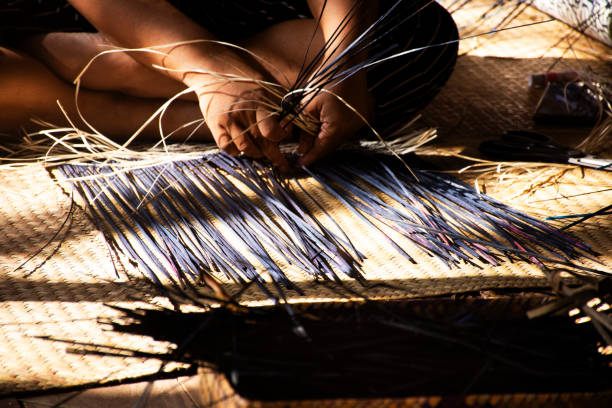 istock Thai craftsmanship technician and professional local artisan knitting wicker unique handmade krachut or sedge products for show and sale in crafts studio workshop at Thale Noi in Phatthalung, Thailand 1746540738