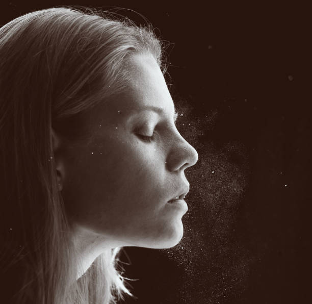 close-up portrait of young woman with glitter in air stock photo