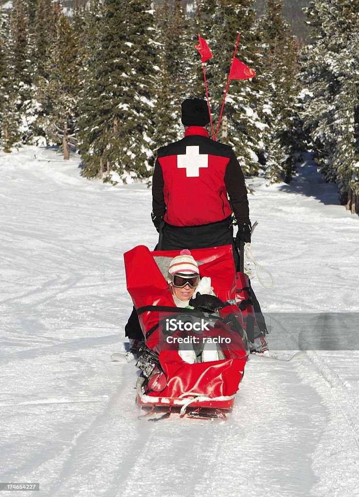 injured skier on sled ski patrol evacuating an injured woman skier. Ski Patrol Stock Photo
