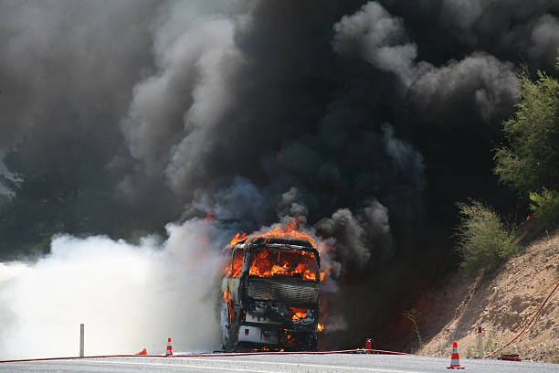 Vehicle on fire with black smoke billowing around it stock photo