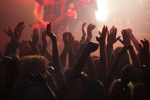 istock Crowd raising arms at a rock concert with red lighting 174654677