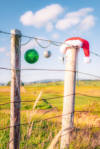 Christmas decorations on the fence of a field in the Southern Hemisphere.