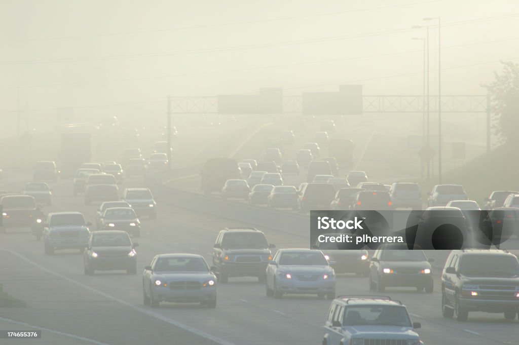 Cars at Rush Hour Driving Through Thick Smog Rush hour traffic with smog.related: Pollution Stock Photo