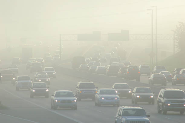 carros na hora do rush dirigindo através de espessura smog - pollution - fotografias e filmes do acervo